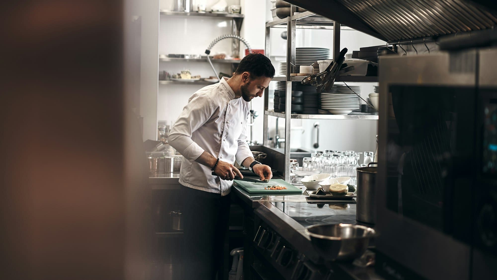 Un cuoco al lavoro alla sua postazione in una cucina professionale