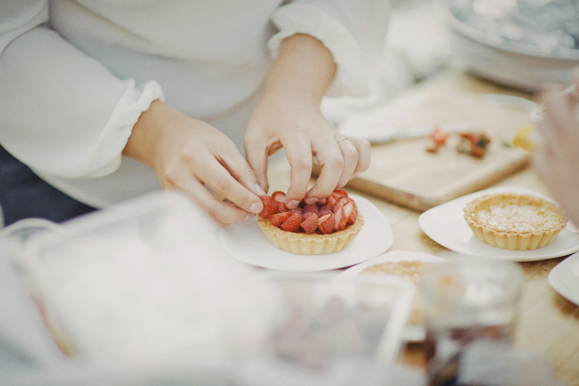 Una pasticcera dispone la frutta su una crostatina